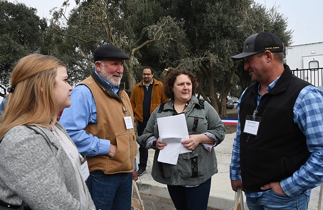 Extension apiculturist Elina Lastro Niño (center) chats with California State Beekeepers' Association (CSBA) affiliates. From left are Brooke Palmer and Steve Godlin of CSBA, Niño and Brad Pankratz of CSBA. In back is Brian Johnson of the UC Davis Department of Entomology and Nematology faculty. (Photo by Kathy Keatley Garvey)