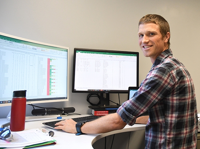Cooperative Extension specialist Ian Grettenberger at his office in 73 Briggs Hall. (Photo by Kathy Keatley Garvey)