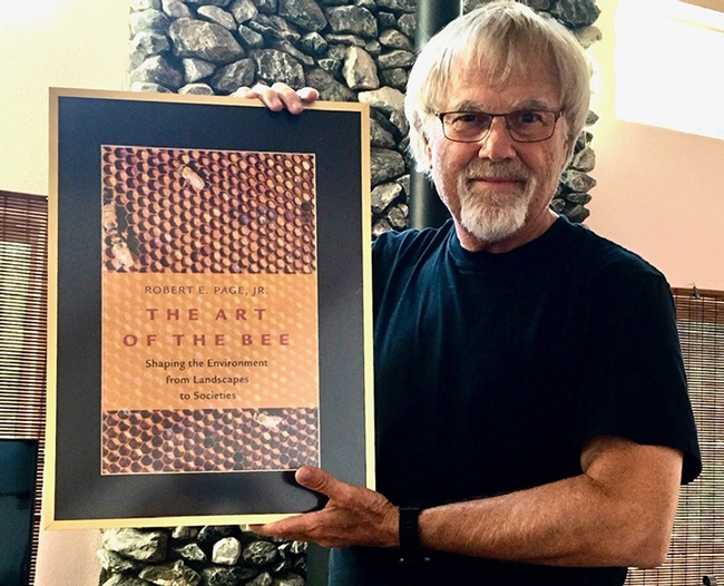 Honey bee geneticist and biologist Robert E. Page Jr. with his book,