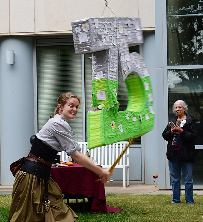 UC Davis entomology doctoral candidate Jill Oberski of the Phil Ward lab, whacks the piñata. (Photo by Kathy Keatley Garvey)