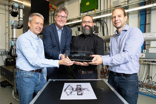 From left: Martin Müller, director of the Institute for Materials Physics at Helmholtz-Zentrum Hereon, and Christian Schroer, leading scientist of DESY's X-ray source PETRA III, accept a model of the newly identified ant from lead author Brendon Boudinot of the Friedrich Schiller University Jena, and co-author Jörg Hammel, beamline scientist at the Hereon measurement station at PETRA III, where the research took place. (Photo courtesy of Marta Meyer, DESY)