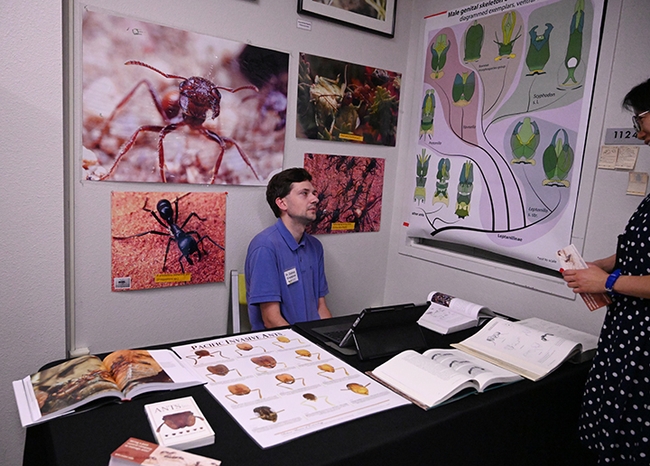 Myrmecologist Zachary Griebenow (pictured), surrounded by books and posters about ants, responds to a question. (Photo by Kathy Keatley Garvey)