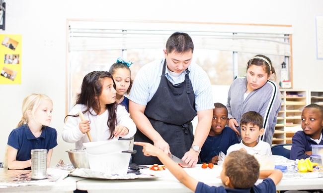 UC Davis medical resident Andrew Nuibe helps kids in an afterschool club prepare healthy snacks.