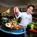 Celebrity chef Martin Yan puts the finishing touch on a Chinese dish.