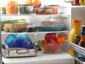 Photo of uncooked turkey and other foods inside a refrigerator.