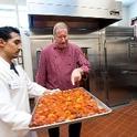 Chef Bob Walden, right, and Arnulfo Herrera, a cook, show off roasted tomatoes at UC Davis. (photo: Gregory Urquiaga / UC Davis)