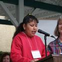 A fourth-grade student reads her winning garden essay as Linda Hahn looks on.
