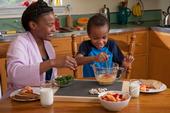 A caregiver and child beating eggs in the kichent - photo SDA's Food and Nutrition Service (FNS), Supplemental Nutrition Assistance Program.