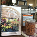 So Easy to Preserve recipe book, pressure canner, and finished jar of canned pinto beans