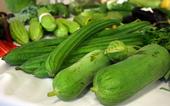 Two bunches of large, green squash on a table. You'll have to keep reading to find the names of these vegetables.
