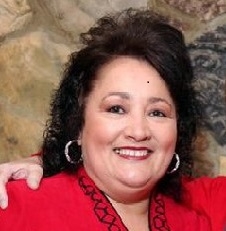 Profile image of Edna Blackhurst, she has black hair and is wearing a red blouse.