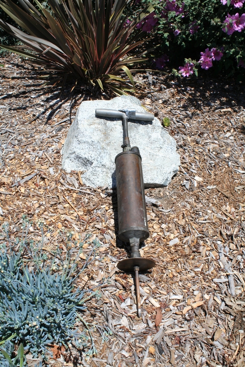 The Fumigun.  Handle at top, applicator pushes the gun into the soil up to plate at bottom.