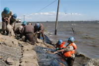 The California Conservation Corps brave flooding waters to sandbag a levee.