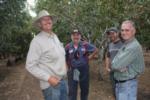 Trunk-shaking pistachio harvester trials: the usual suspects: Erick Nielsen of Nielsen Enterprises, Terry Tompkins of Gold Coast Hydraulics, Robert of Nielsen Enterprises, and Dr. Uriel Rosa