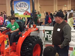 John Taylor Of Bivalve Dairy lets kids sit on a tractor and tells them how it operates