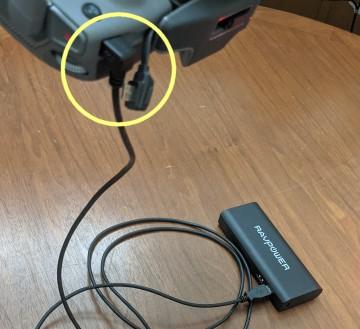 A USB power cord connected to a power pack can charge the controller in flight. An angled port is less likely to pull out.