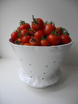 The plentiful harvest is displayed in a hand thrown colander from Peru, home of wild ancestor tomatoes. Photo: Anne-Marie Walker