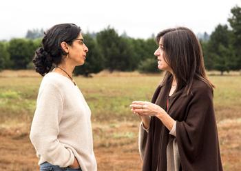 Two women talking in field