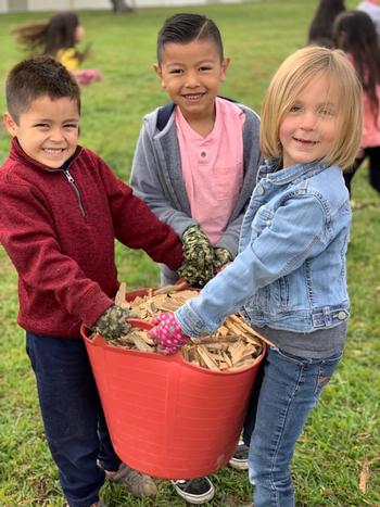 Kids hauling wood chips for the garden. Photo CalFresh Healthy Living, UC