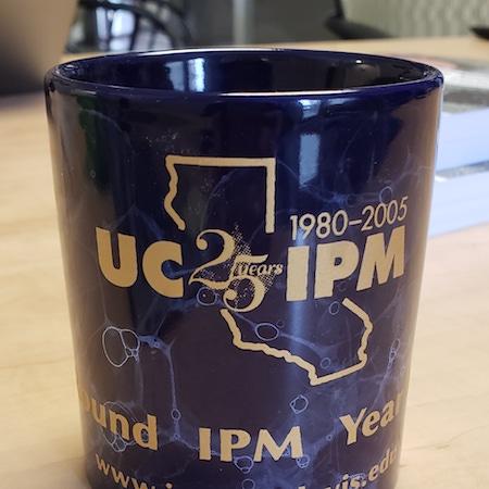 Navy mug with gold lettering. Text: 1980 to 2005 UC IPM 25th year-round IPM yearround