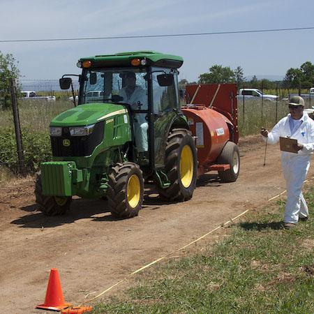 Applicator measuring tractor speed using measured distance (tape) and stop watch. Credit Petr Kosina, UC IPM.