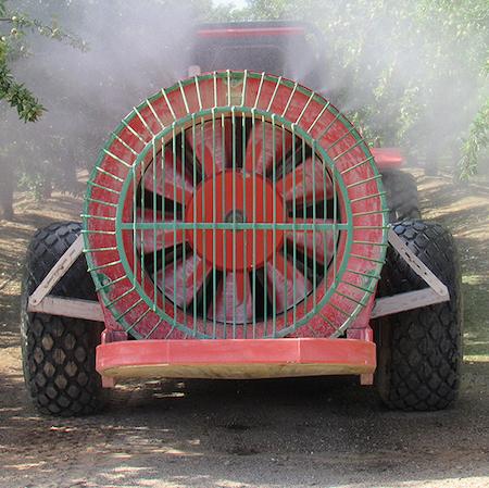 The back of an air blast sprayer spraying between the rows in a nut orchard. Credit: Cheryl A. Reynolds, UC IPM.