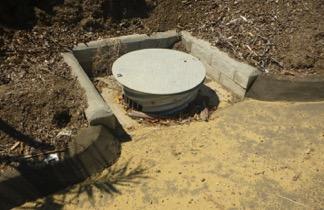 Fig. 9. Drainage inlet surrounded by concrete berms. Water enters inlet from an adjacent asphalt road which is located at a low point on the property.