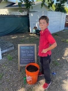 St. Francis of Assisi student carries a bucket of soil for the garden. Photo by Theresa Buhlman.