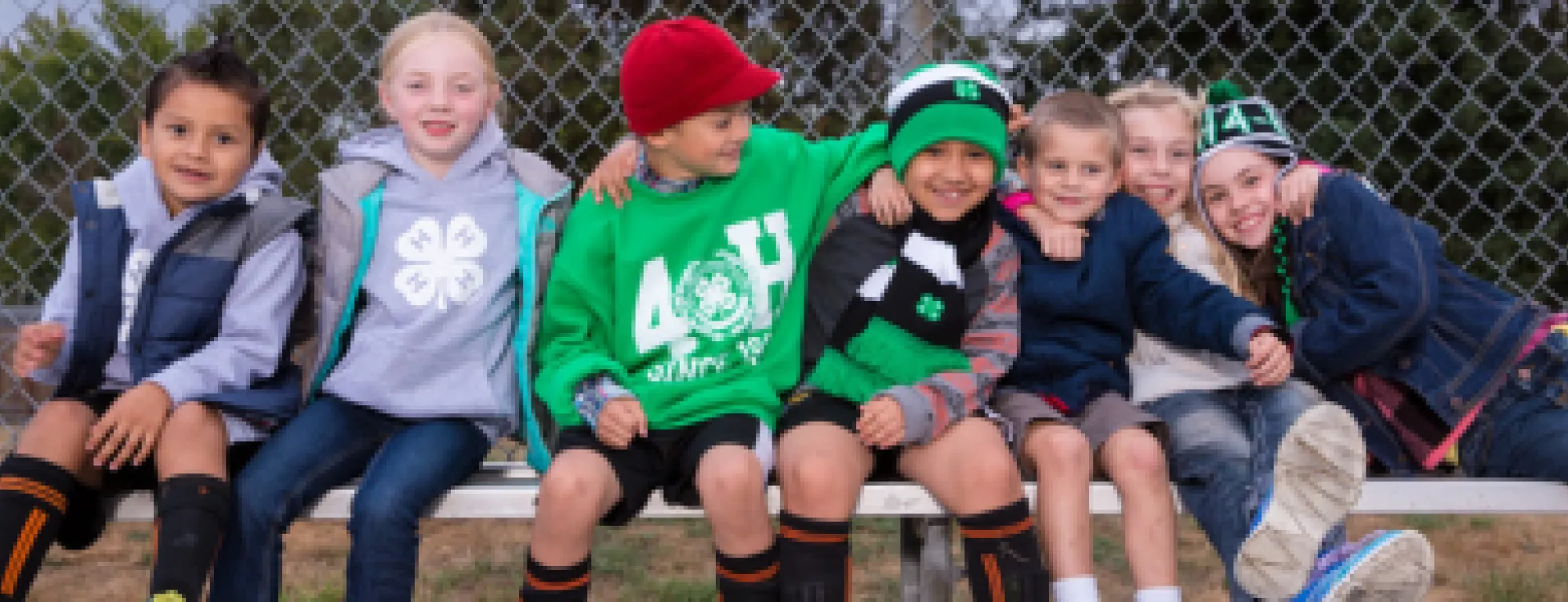 Primary youth sitting on a bench together