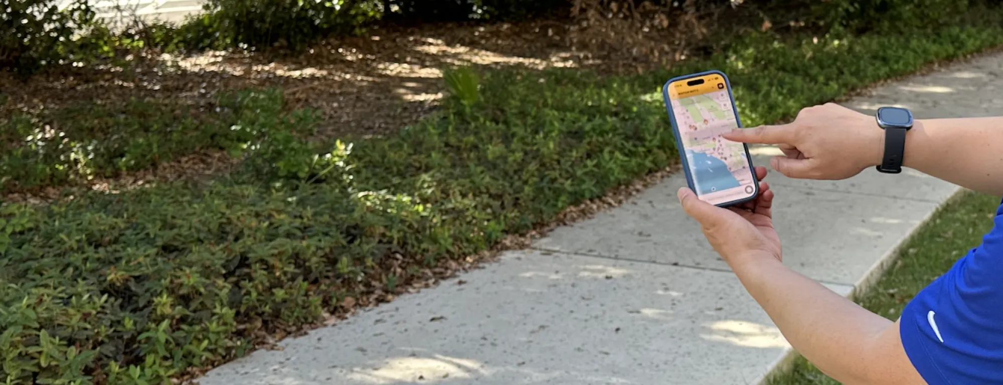 Disembodied hand points to flame image on a California map on a phone