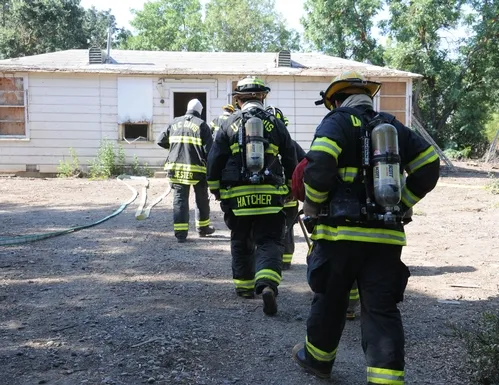 GOING IN--UC Davis firefighters rush into the Baxter House for a control burn, part of a training exercise led by assistant chief Nathan Trauernicht. (Photo by Kathy Keatley Garvey)
