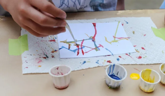 Children especially love Maggot Art. They dip the maggots into water-based paint and let the larvae crawl on the paper. All events are free.  (Photo by Kathy Keatley Garvey)
