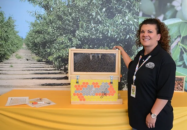 Dixon May Fair's Cammie Garton stands by an observation hive in Madden Hall. (Photo by Kathy Keatley Garvey)