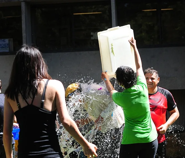 Alifia Merchant of the Hammock lab drenches Bruce Hammock. She just received her master's degree in agriculture and environmental chemistry. In the foreground is executive administrative assistant Louisa Lo. At right is Hammock lab researcher and balloon battle coordinator Christophe Morisseau. (Photos by Kathy Keatley Garvey)