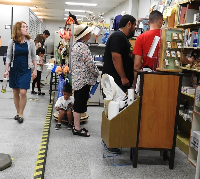 A young boy peruses a book as a crowd gathers in the Bohart Museum gift shop, which is open year around. (Photo by Kathy Keatley Garvey)