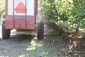 Figure 4. Spreading wood chips (normally the spreader would be set to apply a wider strip)