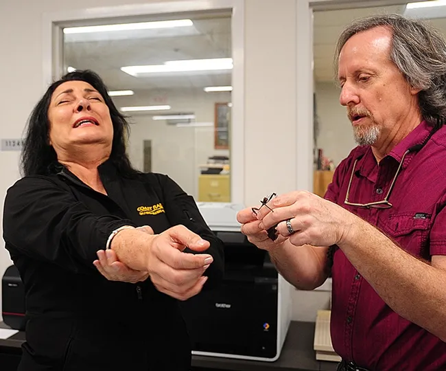 Steve Heydon, senior museum scientist at the Bohart Museum, introduces KUIC's Barbara Hoover to a walking stick--and it started walking up her arm. (Photo by Kathy Keatley Garvey)
