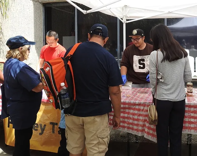 Graduate students Yao Cai (left) of the Joanna Chiu lab and Wei Lin of the Brian Johnson lab, greet participants. (Photo by Kathy Keatley Garvey)