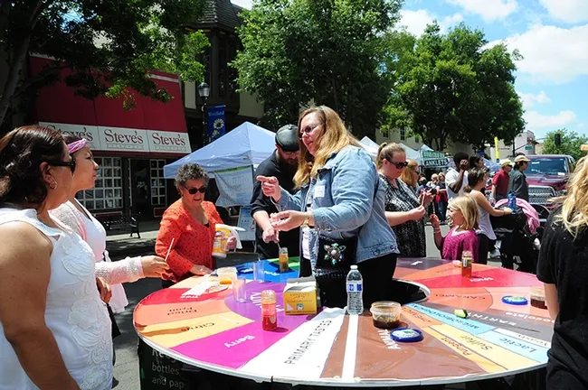 The honey flavor wheel proved to be a honey of an exhibit. That's Amina Harris (in red), coordinator of the California Honey Festival and director of the UC Davis Honey and Pollination Center. (Photo by Kathy Keatley Garvey)