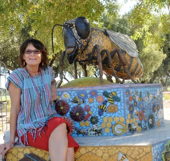 Artist Donna Billick, who created the ceramic-mosaic sculpture, "Miss Beehaven," sits by her work on Aug 17, 2010. The project was funded by Wells Fargo. The haven was installed in the fall of 2009. (Photo by Kathy Keatley Garvey)