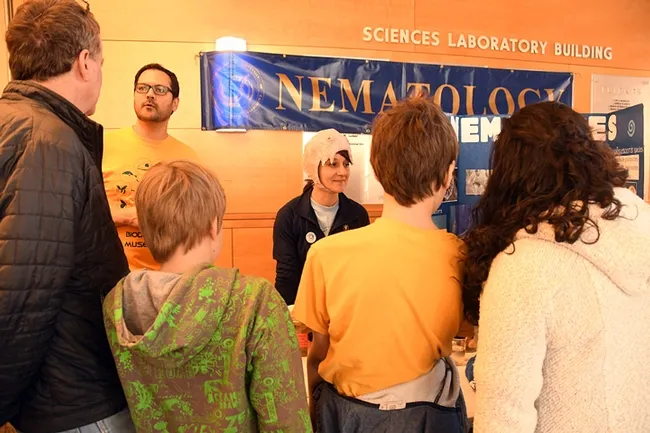 UC Davis diagnostic parasitologist Lauren Camp wears a papier mache nematode hat, modeled after a hookworm mouth. At left is nematologist Chris Pagan, a graduate student in entomology. (Photo by Kathy Keatley Garvey)