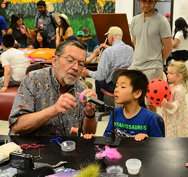 This is how you do it, Fly Fisher Dave Driscoll of Vacaville tells Steven Mao, 7, of Davis. (Photo by Kathy Keatley Garvey)