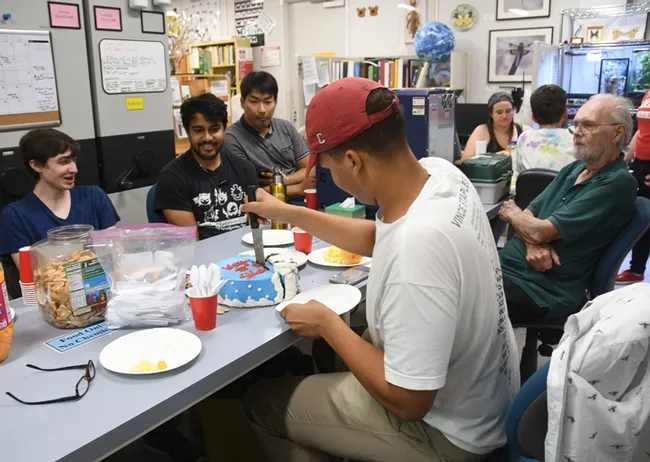Bohart associates watch while Noah Crockette cuts the cake. At left are students Parras McGrath, Lohit Garikipati, and Minsu Kang. At right is Robbin Thorp, UC Davis distinguished emeritus professor of entomology. (Photo by Kathy Keatley Garvey)