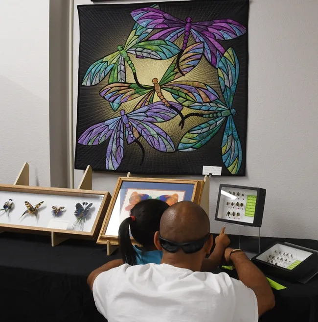 This quilted wall hanging of dragonflies is the work of quiltmaker and seamstress Ann Babicky of Schofield, Wis. Entomologist Jeff Smith, who curates the butterfly and moth specimens in the Bohart, loaned it for the open house. (Photo by Kathy Keatley Garvey)