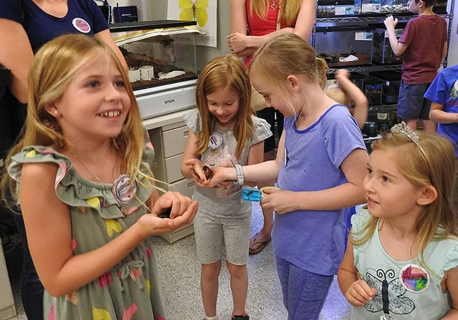 These youngsters enjoyed holding the critters from the live "petting zoo." They included Madagascar hissing cockroaches and walking sticks. (Photo by Kathy Keatley Garvey)