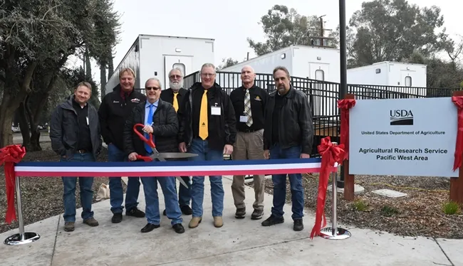 The American Honey Producers Association with the ribbon. Wielding the scissors is Kelvin Adee of Bruce, S.D., president of American Honey Producers. The group later held a conference in Sacramento.