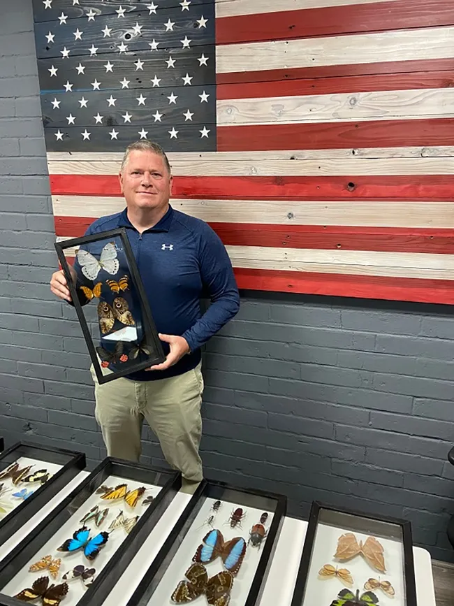 James "Jim" Steed, president and owner of the Neighborly Pest Management, Roseville, with some of the framed insect displays, the work of Jeff Smith. (Photo by Jeff Smith)