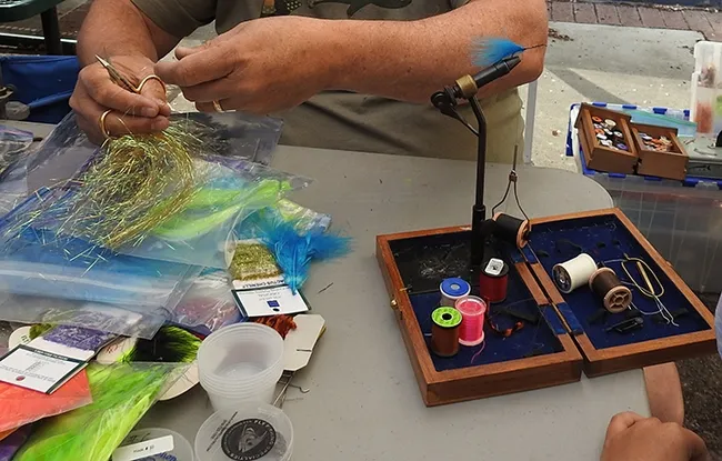 Hands kept busy at the Fly Fishers of Davis tables at Briggs Hall during the 108th annual UC Davis Picnic Day. (Photo by Kathy Keatley Garvey)