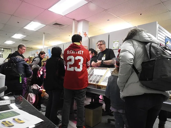 UC Davis law student and San Francisco 49'er fan Ben Padilla of Gilroy, wearing a Christian McCaffrey jersey, listens to carabid beetle specialist Kip Will of UC Berkeley. Padilla left a little early to watch the San Francisco-Dallas game. McCaffrey scored the only touchdown for the 49'ers. (Photo by Kathy Keatley Garvey)