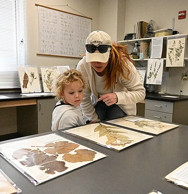 Miles Pickard, 4, listens as his mother, Marissa Pickard, points out a display at the Center for Plant Diversity at the 12th annual UC Davis Biodiversity Museum Day. (Photo by Kathy Keatley Garvey)
